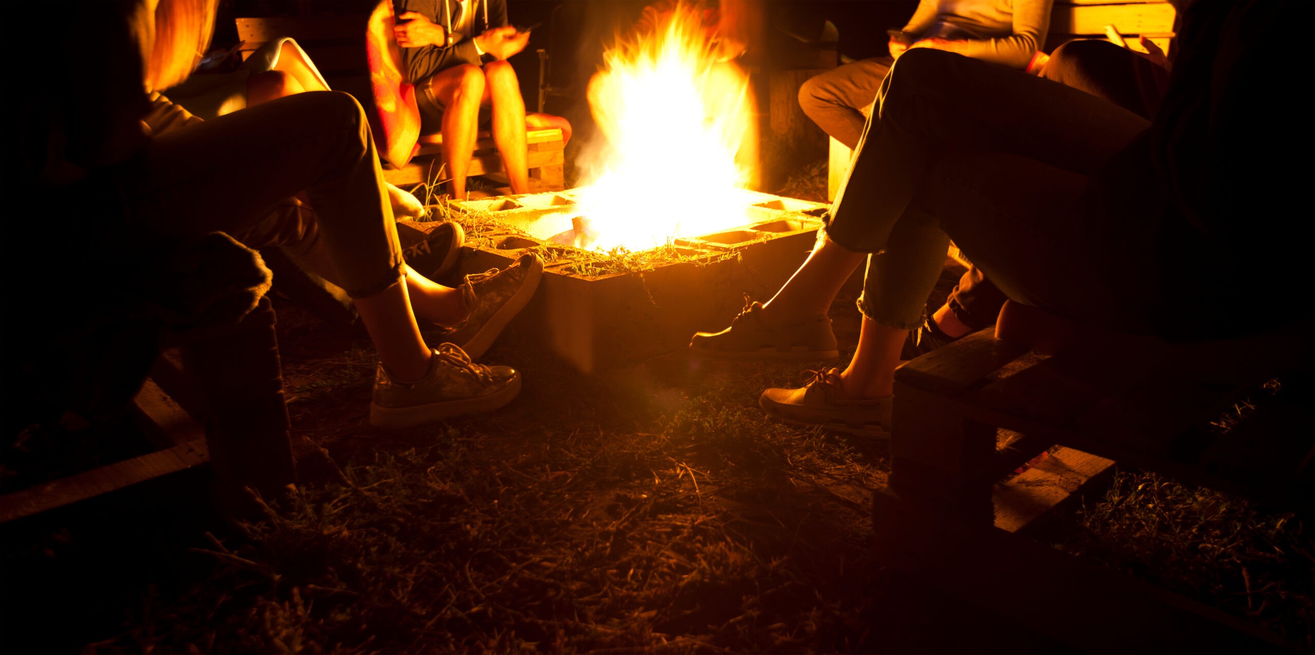 The,Group,Of,Friends,Are,Sitting,Near,The,Bonfire,In